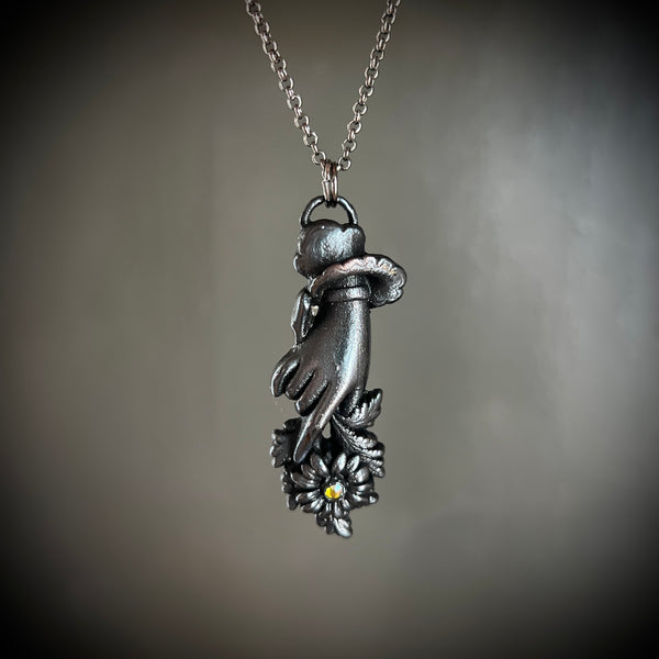 Sentimental Hand Holding a Daisy Necklace with Gunmetal Patina