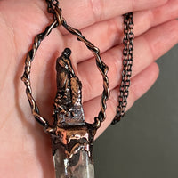 Woman Holding an Anchor with Smoky Quartz and Garnet Copper Necklace