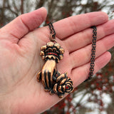 Hand Holding a Rose Copper Necklace