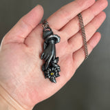 Sentimental Hand Holding a Daisy Necklace with Gunmetal Patina
